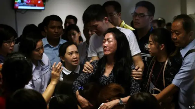 印尼泗水胡安达国际机场内一名QZ8501航班乘客家属收看发现遇难者遗体报道后悲痛万分（30/12/2014）