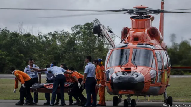 हेलीकॉप्टर से शवों को उतारते राहत कर्मी