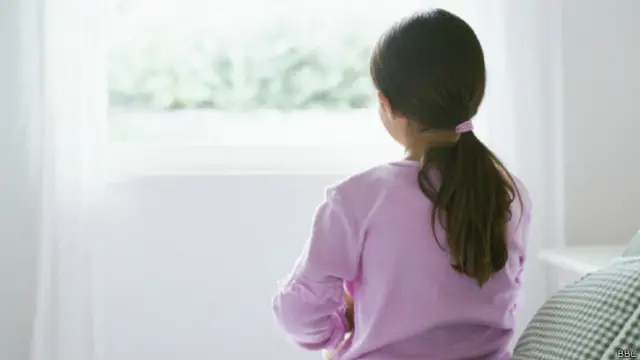 Сидящая на кровати девочка