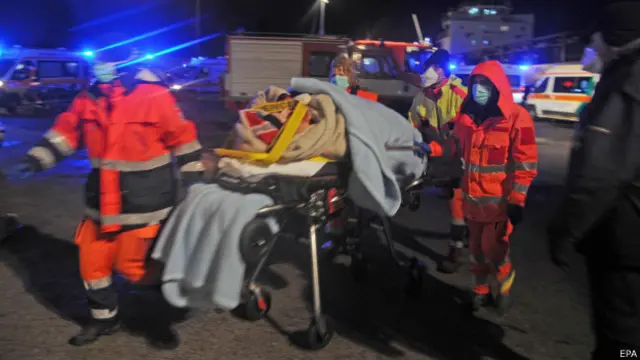 Спасатели везут на носилках беженца