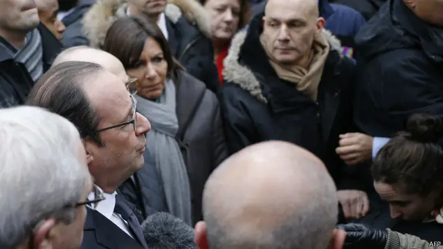 الرئيس الفرنسي في موقع الهجوم يتحدث للصحفيين وبجانبه عمدة باريس آن هيدالغو.