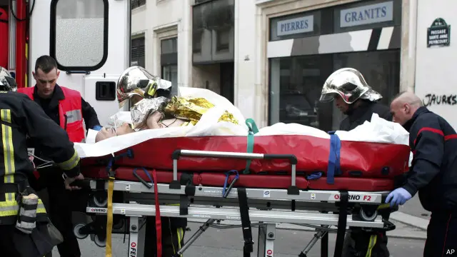 رجال الأسعاف ينقلون أحد الجرحى من مكان الحادث بعد إطلاق النار.