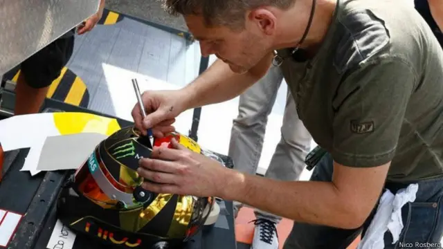 Nico Rosberg muestra al diseñador Jens Munser trabajar en los últimos detalles de su casco.