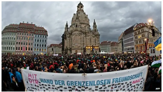 مخالفان گروه پگیدا پارچهای در دست داشتند که روی آن نوشته بود: "دیوار دوستی بدون مرز"