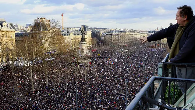 یکی از ساکنان ساختمان‌های اطراف میدان جمهوری در حال نشان دادن جمعیت 