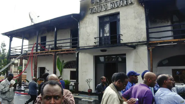 Warga menyaksikan Hotel Taitu setelah dilalap api, hari Senin (12/01).