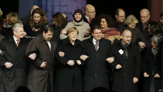 Angela Merkel dan pemuka agama Islam di Jerman saling bergandengan dalam pawai damai.