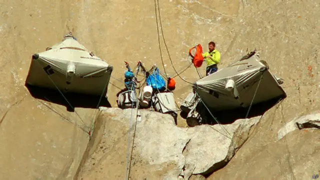 Para pendaki menghabiskan waktu istirahat di tenda yang mengantung