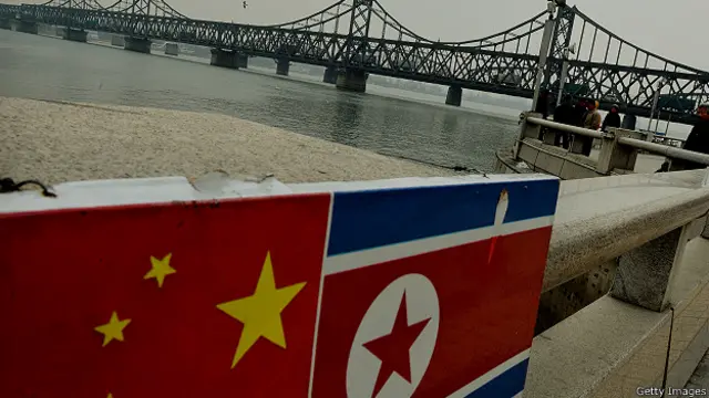 Флаги Китая и Северной Кореи на границе между двумя странами