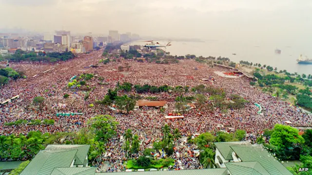 المروحية التي تقل البابا يوحنا بولس الثاني تحلق فوق الجموع في مانيلا في الخامس عشر من يناير / كانون الثاني 1995 قبيل ترؤسه قداسا في الهواء الطلق