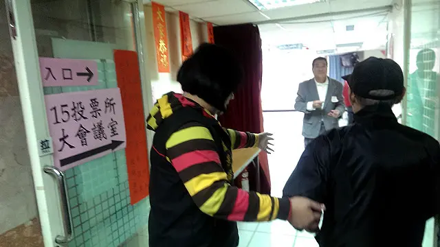 选务人员接待前来投票的老人,协助他们顺利进行投票。