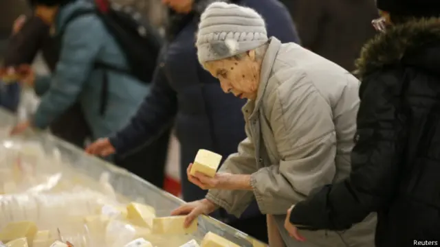 Женщина выбирает сыр в одном из гипермаркетов "Ашан" в Москве