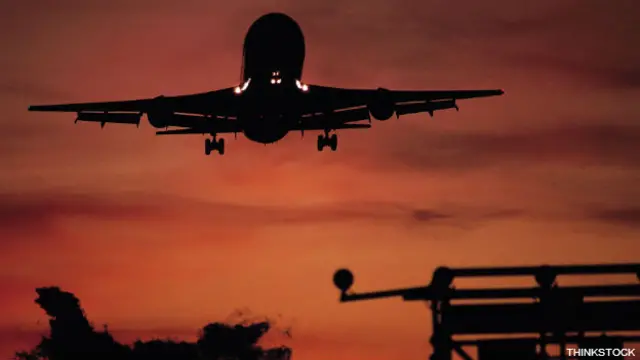 Un avión que se aproxima a una torre de control en un aeropuerto