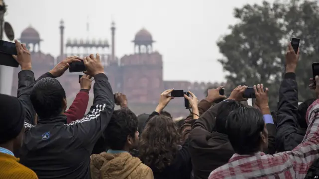 دہلی کے مشہور لال قلعے کے قریب ہونے والی یومِ جمہوریہ کی پریڈ دیکھنے والے شائقین اپنے موبائل فونز سے تصاویر بنا رہے ہیں۔