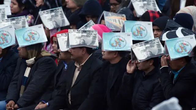 بارش میں بھیگنے سے بچنے کے لیے اکثر مہمان یومِ جمہوریہ کی پریڈ کے پروگرام کی کاپیاں سر پر رکھے ہوئے ہیں۔