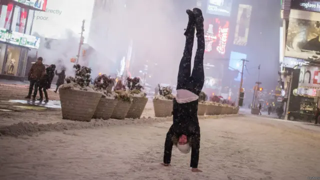 فتاة تظهر مهاراتها الجسدية في ميدان تايمز في ولاية نيويورك خلال العاصفة الثلجية التي اجتاحت الولاية وولايات أخرى مثل بوسطن وفيلادلفيا.