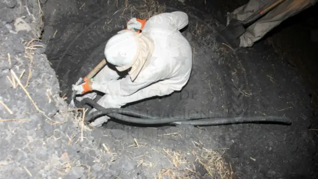 Agentes revisan un sitio de robo de gasolina a un ducto de Pemex. Foto: PGR