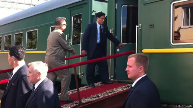 Лидер КНДР Ким Чен Ир (слева на втором плане), совершающий визит в РФ, входит в вагон бронированного поезда на станции Бурея в Амурской области