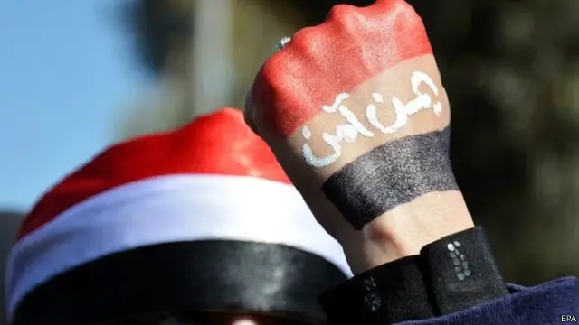 يد امرأة مكتوب عليها "يمن آمن" في مظاهرة ضد الحوثيين