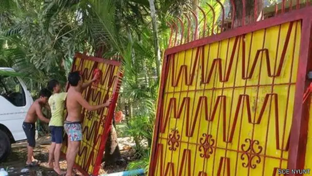 Gerbang itu dicat merah dan kuning, sesuai dengan warna Partai Liga Nasional untuk Demokrasi.