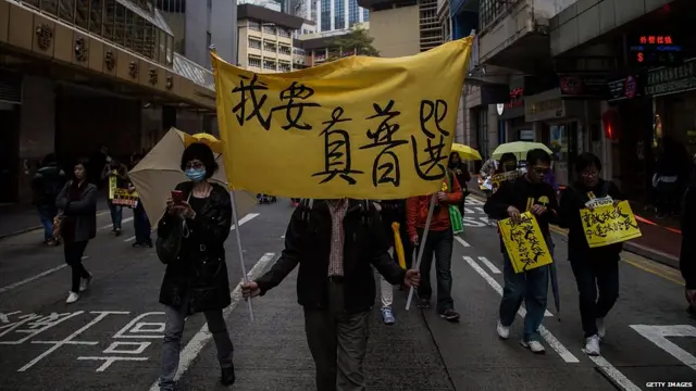 مظاہرین نے بہت سے کتبے اور کپڑے کے بینر اٹھا رکھے تھے جن پر ’میں حقیقی عالمی جمہوریت چاہتا ہوں‘ جیسے نعرے درج تھے۔ 