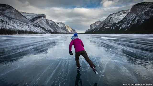 Una persona patina en un lago helado en Canadá. Fotografía: Paul Zizka. 