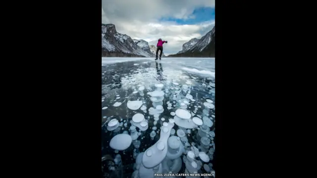 Burbujas de gas metano bajo la superficie helada de un lago. Fotografía: Paul Zizka. 
