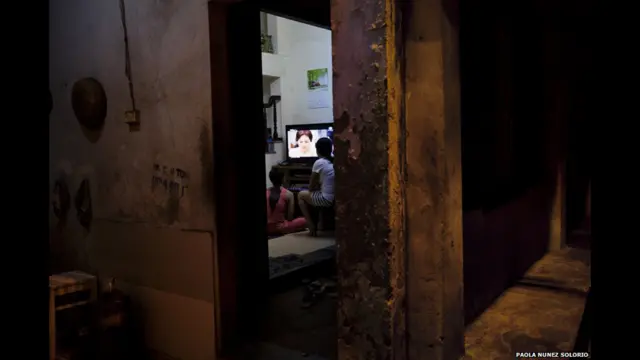 Rakyat menonton televisi. Paola Nunez Solorio