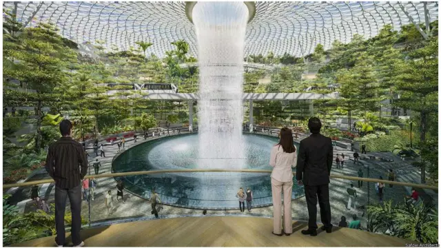Sân bay Changi, Singapore (khánh thành 2018).
Kiến trúc sư Moshe Safdie, người thiết kế khu Habitat 67 ở Montreal, bắt đầu thi công sân bay Changi từ 12/2014. “Thung Lũng Rừng”, “Vườn Ngọc Quý” và với thác nước cao 40m được gọi là ‘Cơn Lốc Mưa Xoáy’ là một số nét khiến sân bay trông như Cảnh Thần Tiên hơn là một điểm nút của hàng không; nằm trong khoảng 134.000 m2 của vòm thủy tinh là các cây cao, cọ và dương xỉ. Được dự kiến hoàn thành vào năm 2018, tổ hợp Jewel được nối với nhà ga cũ bằng các cầu bộ hành, nó tạo ra diện tích cho các cửa hàng và tiệm ăn dọc theo cảnh xanh ngát của cây cối. Kiến trúc sư Safdie nói rằng dự án này là một kiểu mẫu mới của không gian đô thị.”