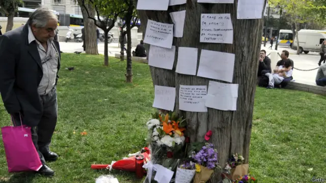 Flores y mensajes dejadas en un árbol al pensionista Dimitris Christoulas, quien se suicidó en 2012