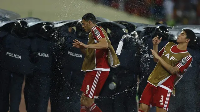 پولیس گھانا کے کھلاڑیوں کے گرد حصار قائم کر کے انھیں میدان سے باہر لے گئی۔