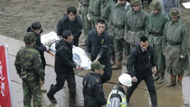 搜寻人员将遗体抬离现场