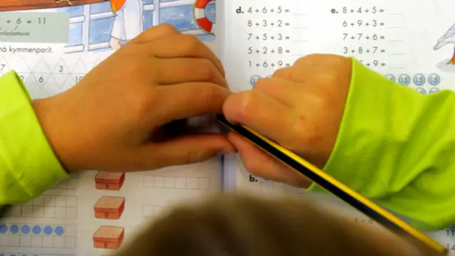 Manos de un niño con un lápiz sobre un cuaderno