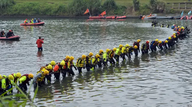 搜救人员在基隆河台北—新北交界段落搜寻复兴航空GE235航班失踪者（台湾中央社图片8/2/2015）