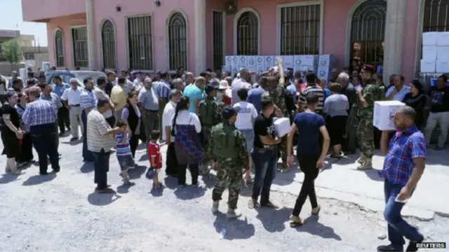 المسيحيون العراقيون يتلقون مساعدات بعد فرارهم من الموصل.