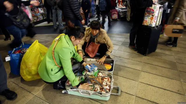 香港街头两名中国大陆游客打开行李箱席地收拾（9/2/2015）