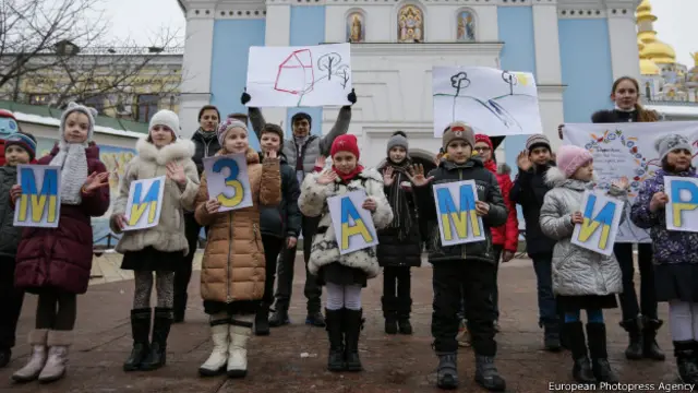 дети держать плакат "Мы за мир" на украинском языке