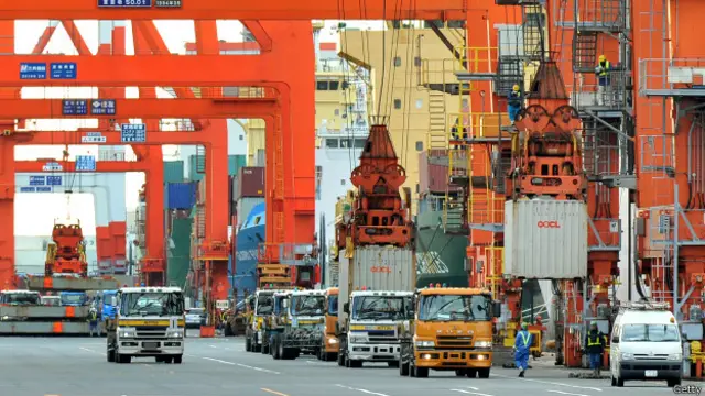 Grúas cargan contenedores a un barco en un puerto chino