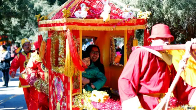 ایک ماں اپنے بچے کے ساتھ رواتی سواری کی سیر سے لطف اندوز ہو رہی ہے