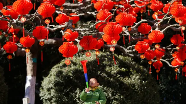 ایک بچہ جشن بہار کے موقعے پر سجائے گئے پیڑوں کو دیکھ رہا ہے