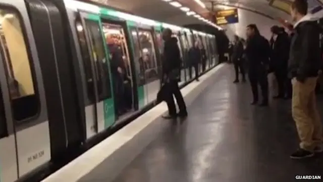 Un pasajero es bloqueado por un grupo de aficionados en el metro de París.