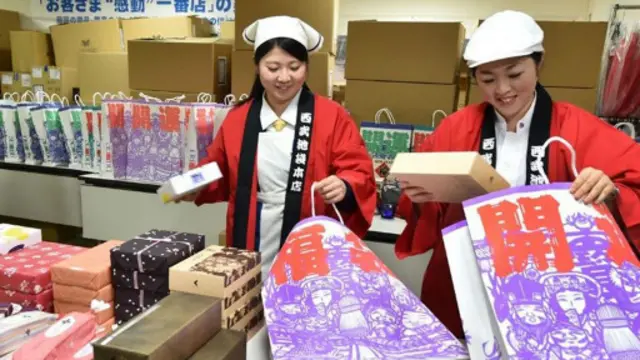 日本商店店员将商品装入“福袋”,进行促销