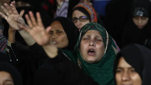 احتجاج میں خواتین حملے میں ہلاک ہونے والے اپنے بچوں کی تصاویر لے کر کھڑی تھیں