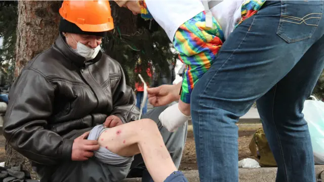 Чоловікові обробляють рани від гумових куль, отримані на барикадах біля торгового центру "Глобус".