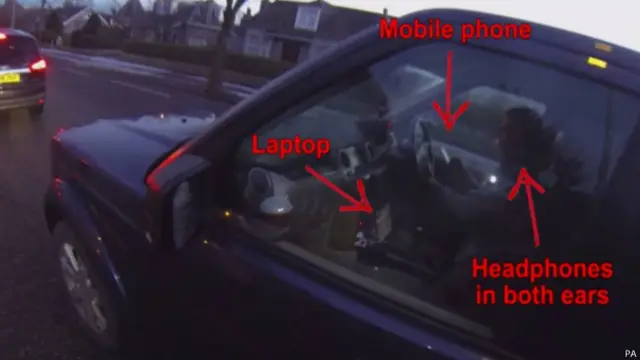 这位驾车者，拿着手机、带着耳机、看着手提电脑，还有多少精力驾车看路？