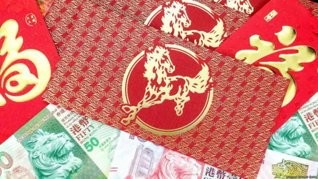Hầu hết các đồ vật truyền thống dùng trang trí trong dịp Tết đều là màu đỏ, biểu tượng cho sự may mắn và giúp xua đuổi tà ma. Trong dịp Tết, cha mẹ thường mừng tuổi con trẻ phong bao lì xì màu đỏ, với những khoản tiền thường là số chẵn để cầu may. (Hình: Michael Siward/Getty)