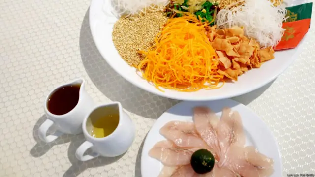 Vào ngày mùng 7 Tết, người Hoa ở Malaysia và Singapore tổ chức lễ ẩm thực truyền thống 'lo hei', tiếng Quảng Đông có nghĩa là “đoán vận cát tường". Các gia đình, bạn bè tụ tập nhau để đoán xem các nguyên vật liệu làm món gỏi cá này gồm những gì, vừa đoán vừa hò reo những câu chúc may mắn. Món gỏi cá thường làm với củ cải xanh, củ cải trắng, cà rốt, gừng muối chua và cá tươi thái lát, mà thường là cá hồi, thêm các gia vị là sốt mận và ngũ vị hương. (Hình: Lan Lan Tee/Getty)