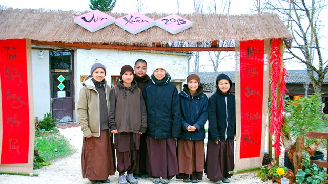 Làng Mai như chuyển mình, khoe sắc trong mùa Xuân về và đặc biệt qua những gương mặt thật trẻ trung của các sư cô, những nhân vật không thể thiếu trong ngày hội năm mới ở Làng. Nữ trụ trì cùng các sư chị, sư em đồng tu ghi lại một khoảnh khắc bên cổng chào của Vườn xuân đón năm mới.