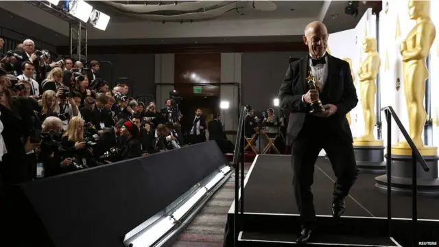 فلم وپلیش کے لیے معاون اداکار کا ایوارڈ حاصل کرنے والے جے کے سیمنز نے زور سے ٹرافی پکڑ رکھی ہے۔