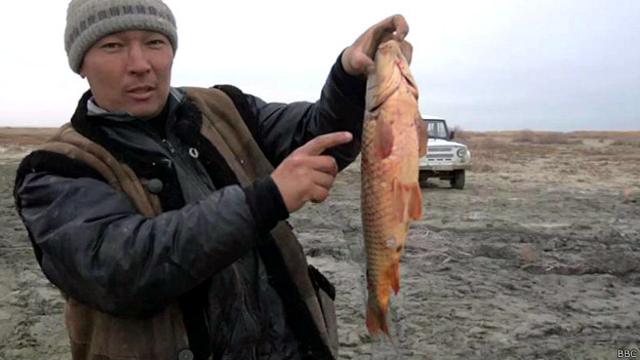 Hombre con un pescado en el mar de Aral
